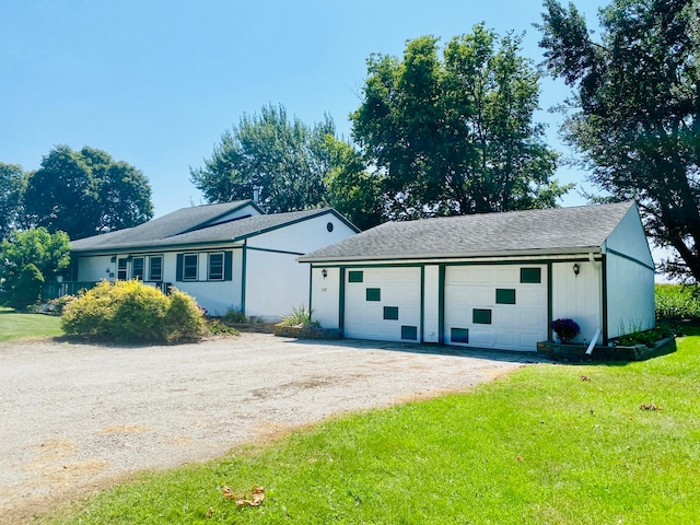 ranch-style home with an outdoor structure, a garage, and a front lawn