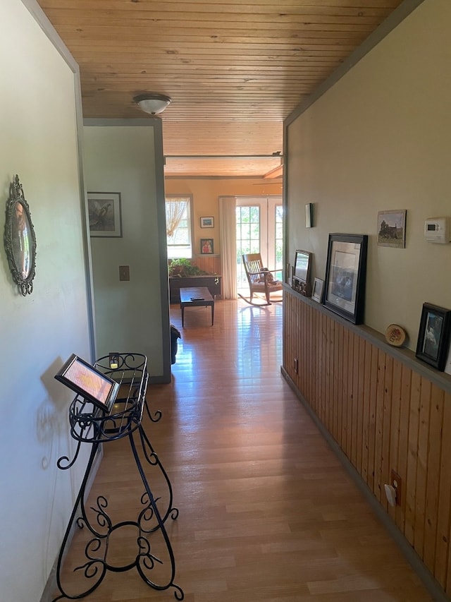 hall featuring wood ceiling, hardwood / wood-style flooring, and wood walls