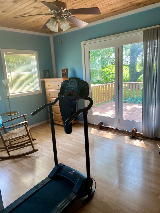 exercise room with wood ceiling, crown molding, ceiling fan, and hardwood / wood-style floors