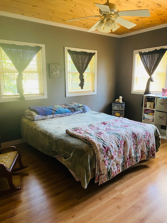 bedroom featuring ceiling fan, hardwood / wood-style floors, wooden ceiling, and multiple windows