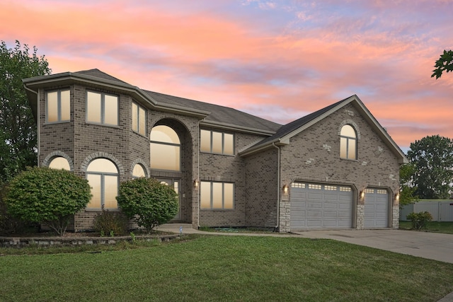 view of front of home with a garage and a yard