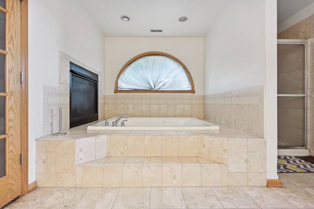 bathroom featuring shower with separate bathtub