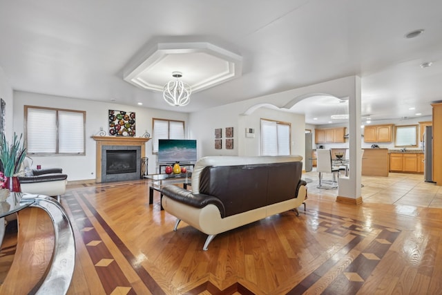 living room with light wood-type flooring and a notable chandelier