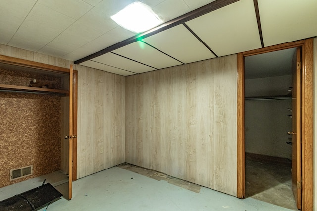 basement featuring wood walls