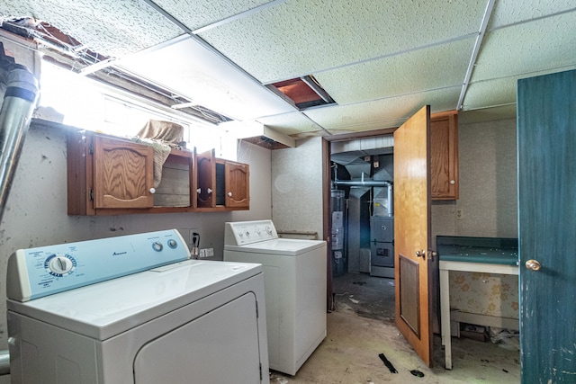 laundry room with gas water heater, cabinets, and washing machine and dryer