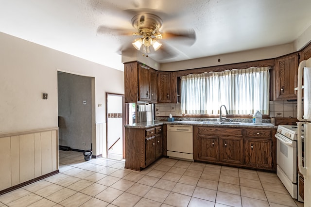 kitchen featuring backsplash, white appliances, sink, light tile patterned flooring, and ceiling fan