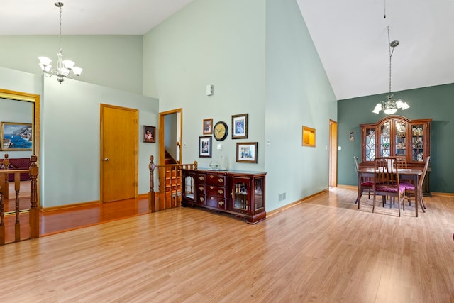 interior space with light hardwood / wood-style floors, high vaulted ceiling, and a chandelier