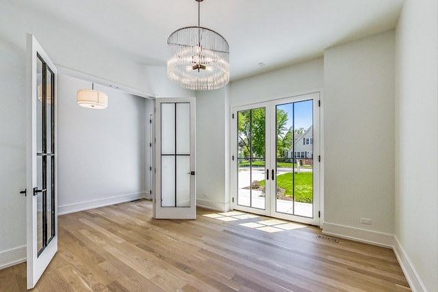 172 E Crescent Ave, Elmhurst, IL 60126 - unfurnished dining area with french doors, wood finished floors, baseboards, and a chandelier