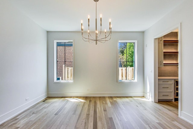 172 E Crescent Ave, Elmhurst, IL 60126 - unfurnished dining area with a chandelier, light wood-style flooring, and baseboards