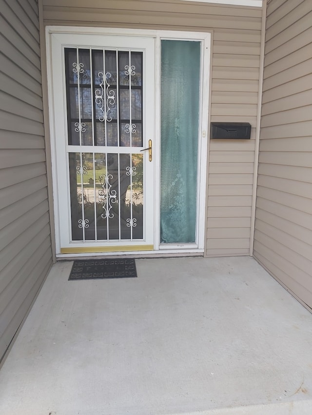 view of exterior entry with a patio area