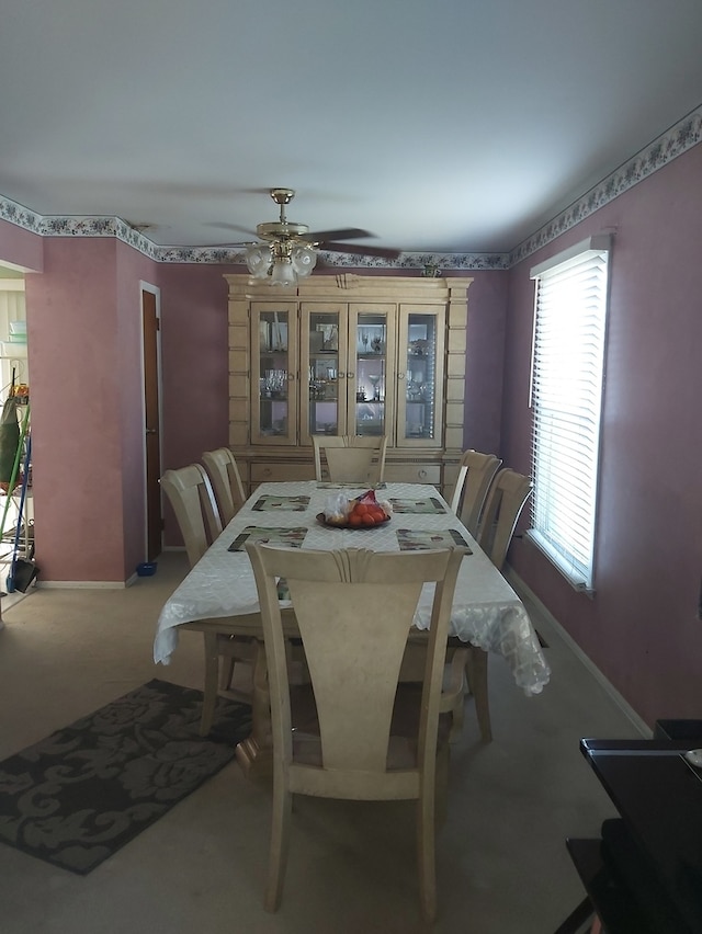 dining room with light colored carpet and ceiling fan