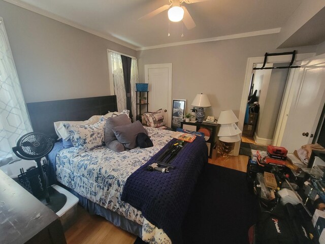 bedroom with crown molding, ceiling fan, and hardwood / wood-style floors