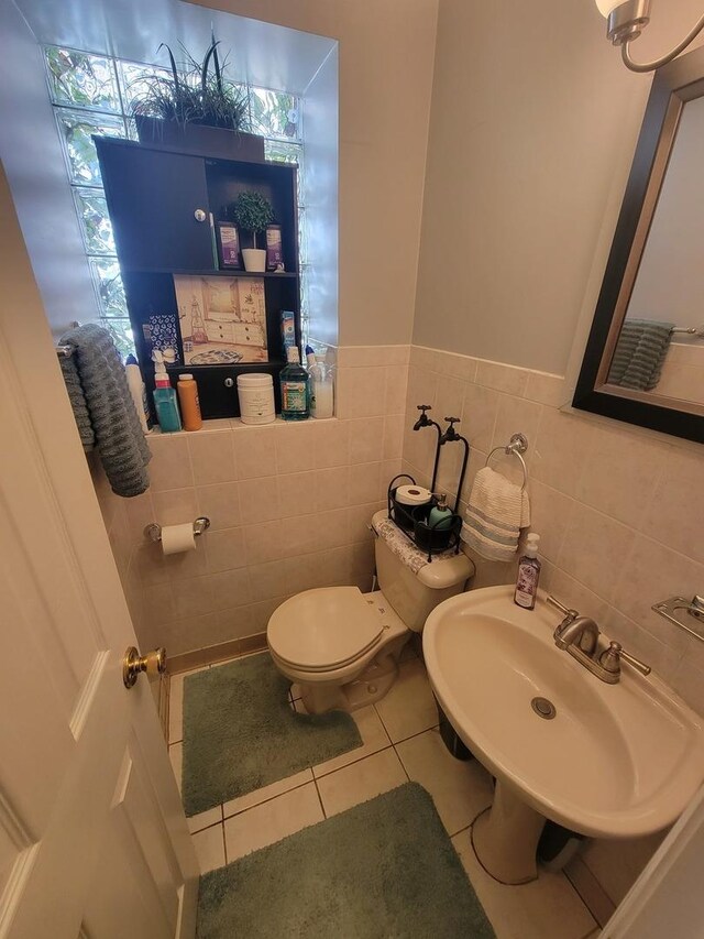 bathroom featuring tile walls, toilet, sink, and tile patterned floors