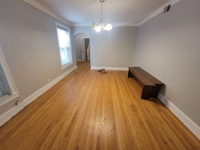 spare room featuring crown molding, an inviting chandelier, and light hardwood / wood-style floors