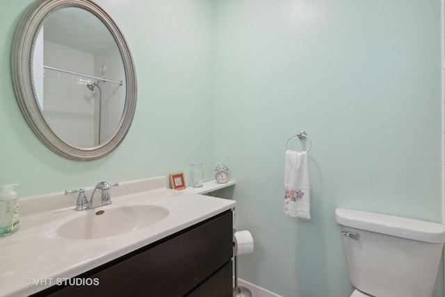 bathroom featuring walk in shower, vanity, and toilet