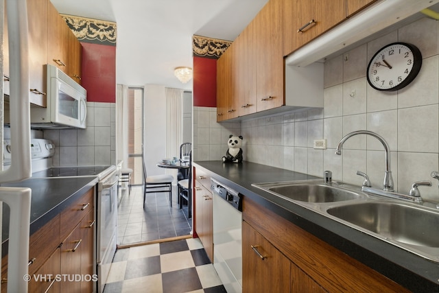 kitchen with sink, white appliances, and decorative backsplash