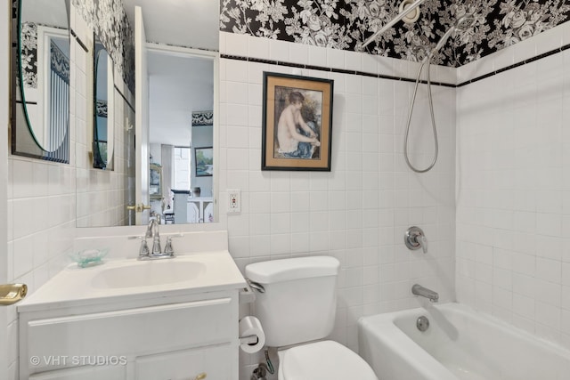 full bathroom with tiled shower / bath, vanity, tile walls, and toilet