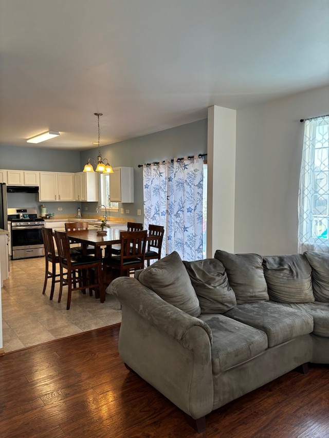 living room with hardwood / wood-style flooring, sink, and a chandelier