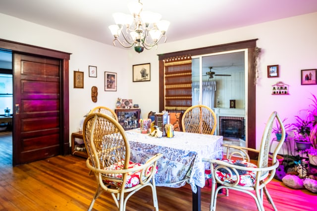 dining space featuring ceiling fan with notable chandelier and hardwood / wood-style floors