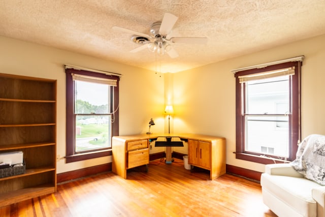 interior space featuring light wood-type flooring, ceiling fan, and a textured ceiling