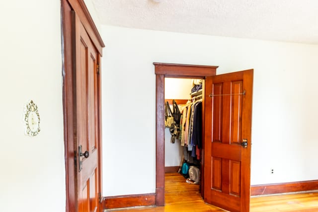 bedroom with a closet, a textured ceiling, and light hardwood / wood-style flooring