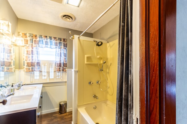 bathroom with vanity, a textured ceiling, wood-type flooring, and shower / bathtub combination with curtain