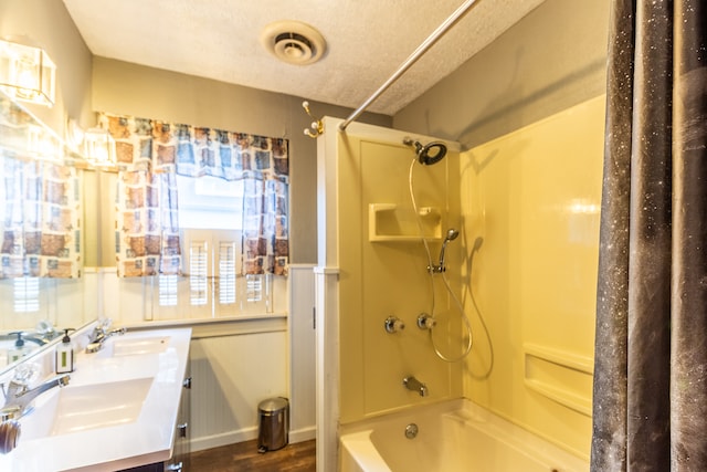 bathroom featuring shower / bathtub combination with curtain, hardwood / wood-style flooring, a textured ceiling, and vanity