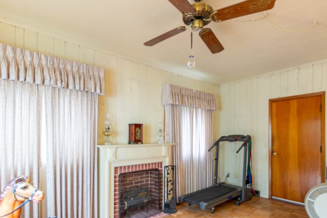 workout room with a fireplace, parquet floors, and ceiling fan