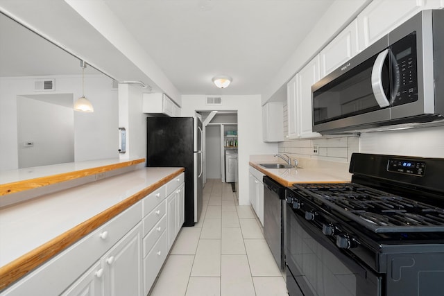 kitchen featuring sink, decorative light fixtures, appliances with stainless steel finishes, and white cabinets