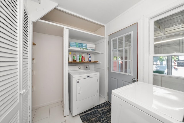 clothes washing area with light tile patterned floors and washer and dryer