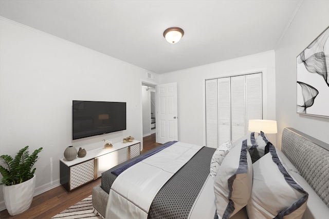 bedroom featuring a closet, dark hardwood / wood-style floors, and ornamental molding