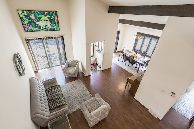 living room with lofted ceiling, a chandelier, plenty of natural light, and dark hardwood / wood-style flooring