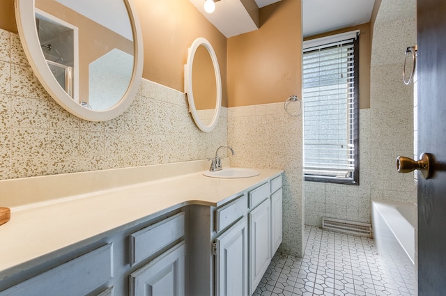 bathroom with vanity, tile walls, tile patterned flooring, and a wealth of natural light