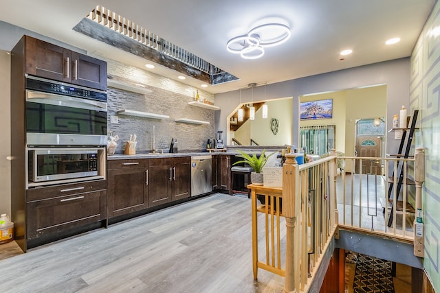 kitchen with dark brown cabinetry, tasteful backsplash, decorative light fixtures, light hardwood / wood-style flooring, and appliances with stainless steel finishes