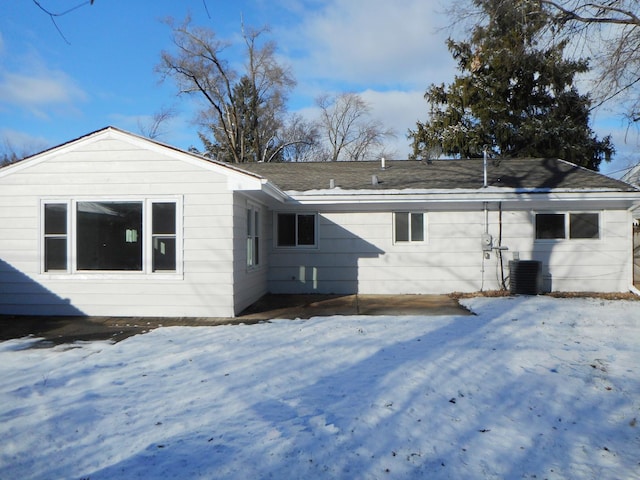 snow covered property with central AC