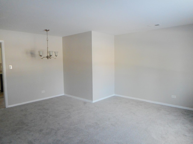 unfurnished room featuring carpet flooring and an inviting chandelier