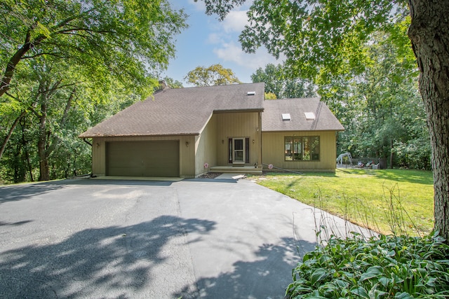 view of front of property with a garage and a front lawn