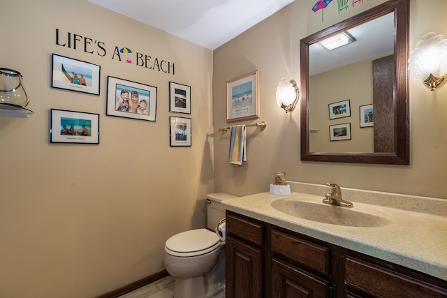 bathroom featuring tile patterned flooring, toilet, and vanity