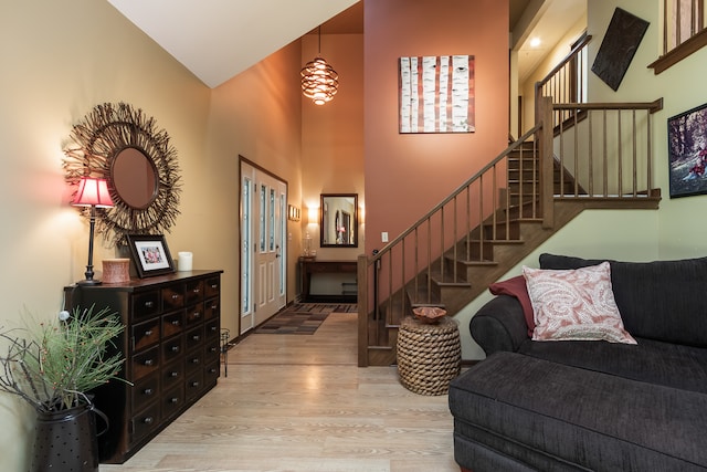 entryway with wood-type flooring and high vaulted ceiling