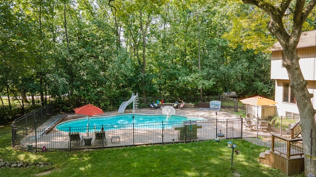 view of pool with a yard and a water slide