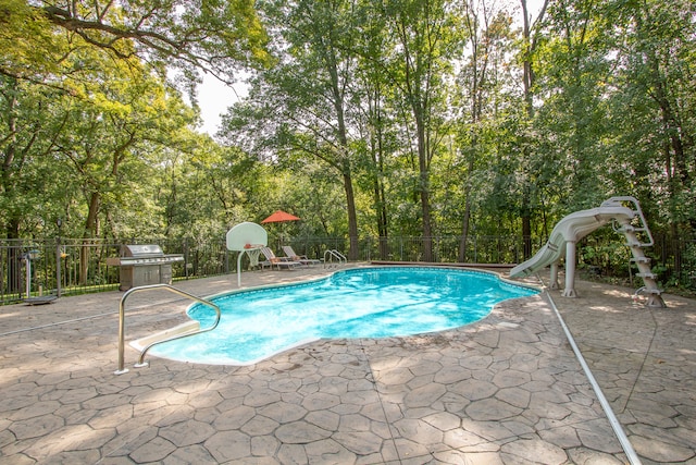 view of pool featuring grilling area, a water slide, and a patio