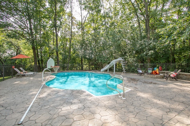 view of pool with a water slide and a patio area