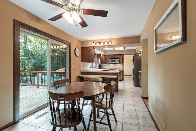 dining room with ceiling fan, light tile patterned floors, and sink