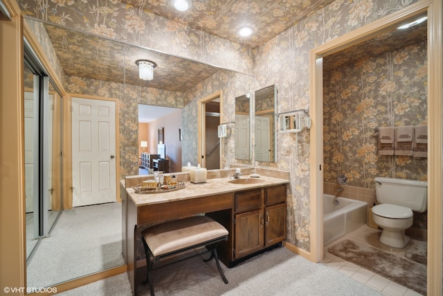 bathroom featuring toilet, a bathing tub, and vanity