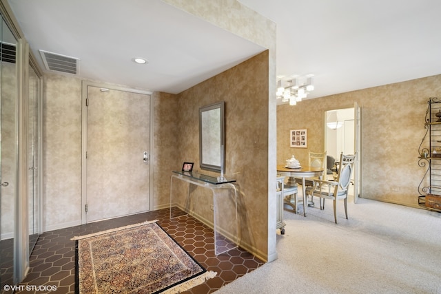 entrance foyer with dark colored carpet