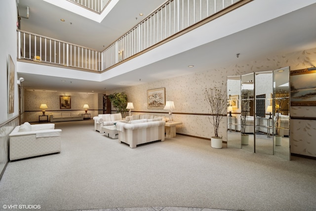 living room with a skylight, carpet floors, and a towering ceiling