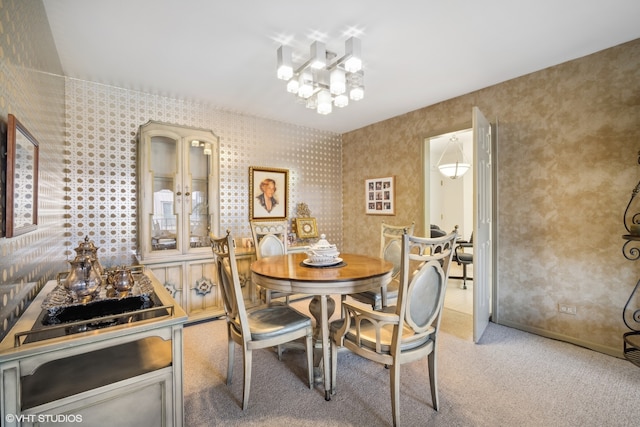 dining room with light colored carpet and a notable chandelier