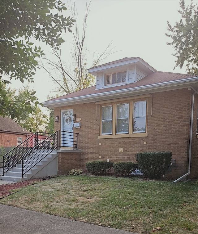 bungalow-style house featuring a front lawn