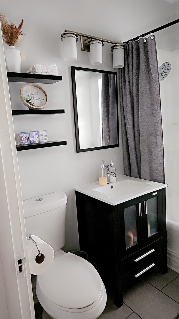 full bathroom with vanity, shower / tub combo with curtain, toilet, and tile patterned floors