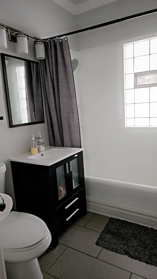 full bathroom with tile patterned floors, vanity, toilet, and shower / bathtub combination with curtain